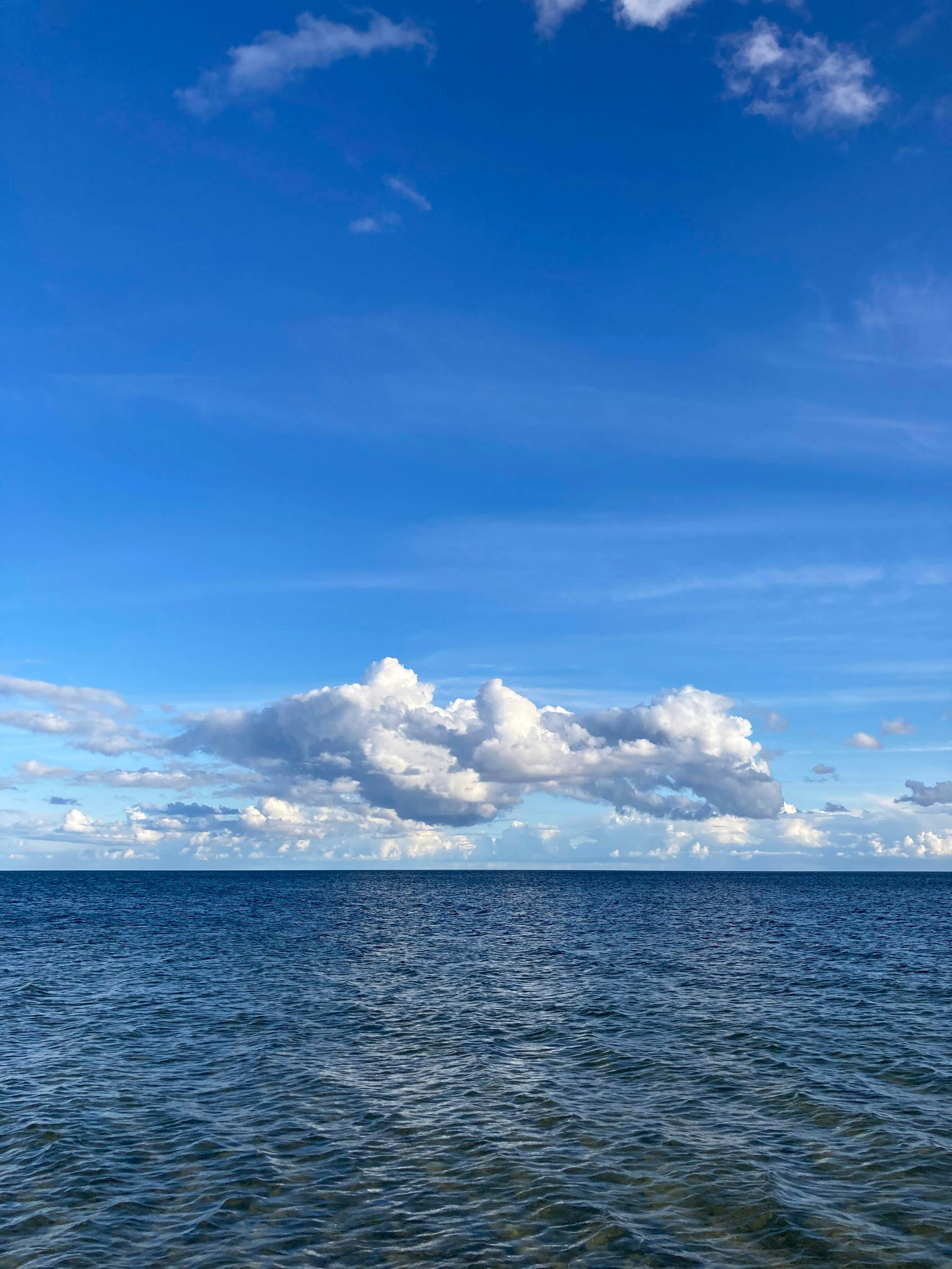 a body of water with clouds above it