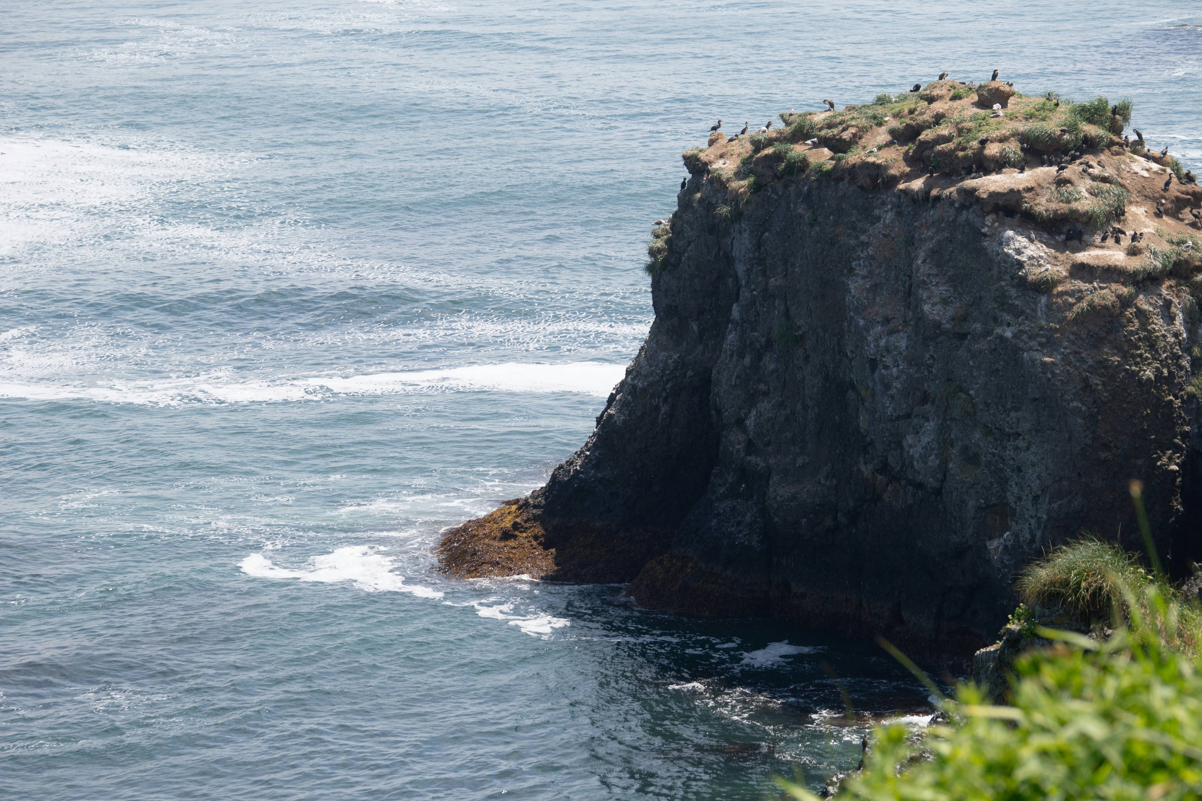 A rocky coastline juts out into the ocean.