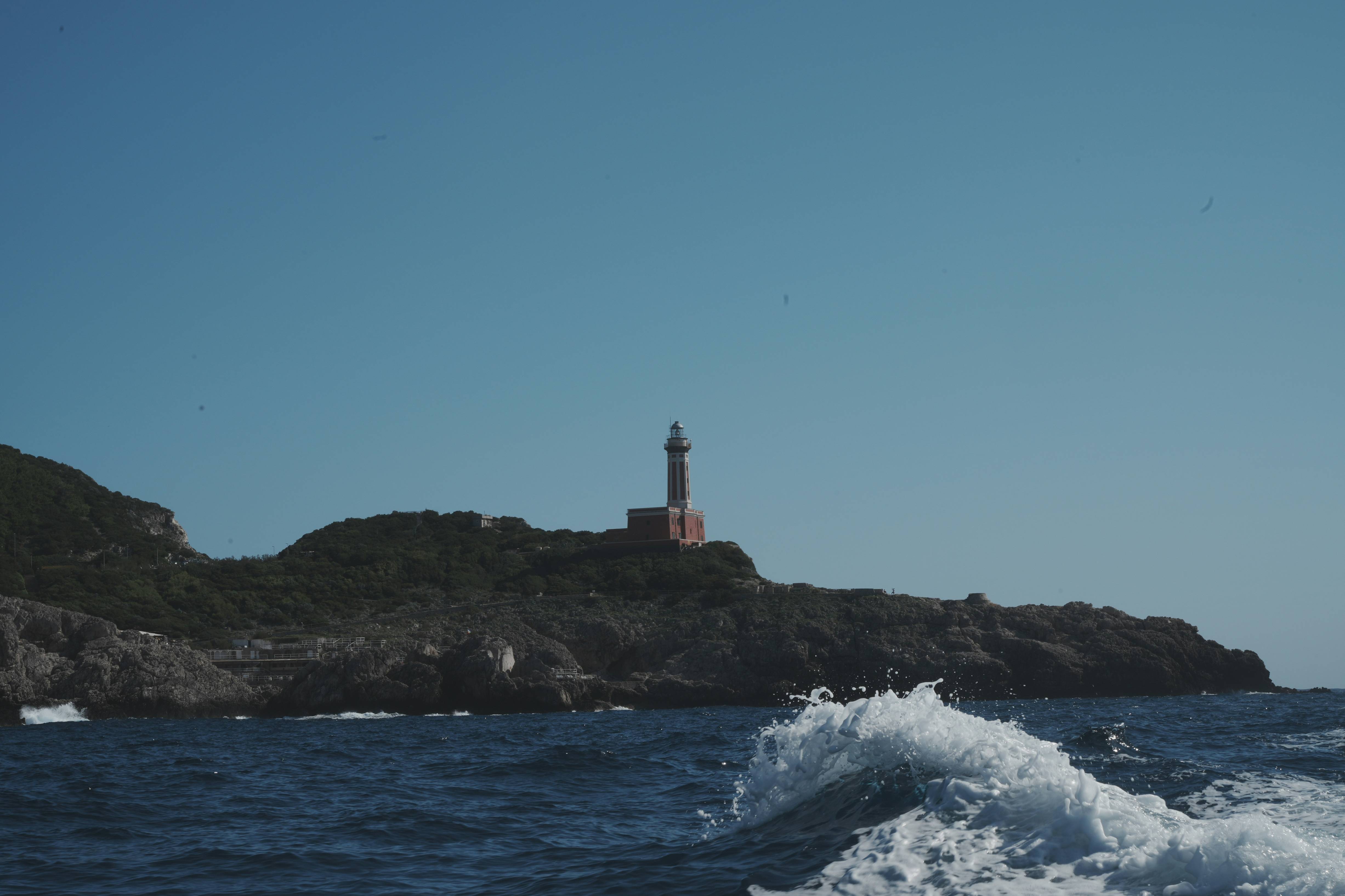 Lighthouse on a rocky coast with choppy ocean waves