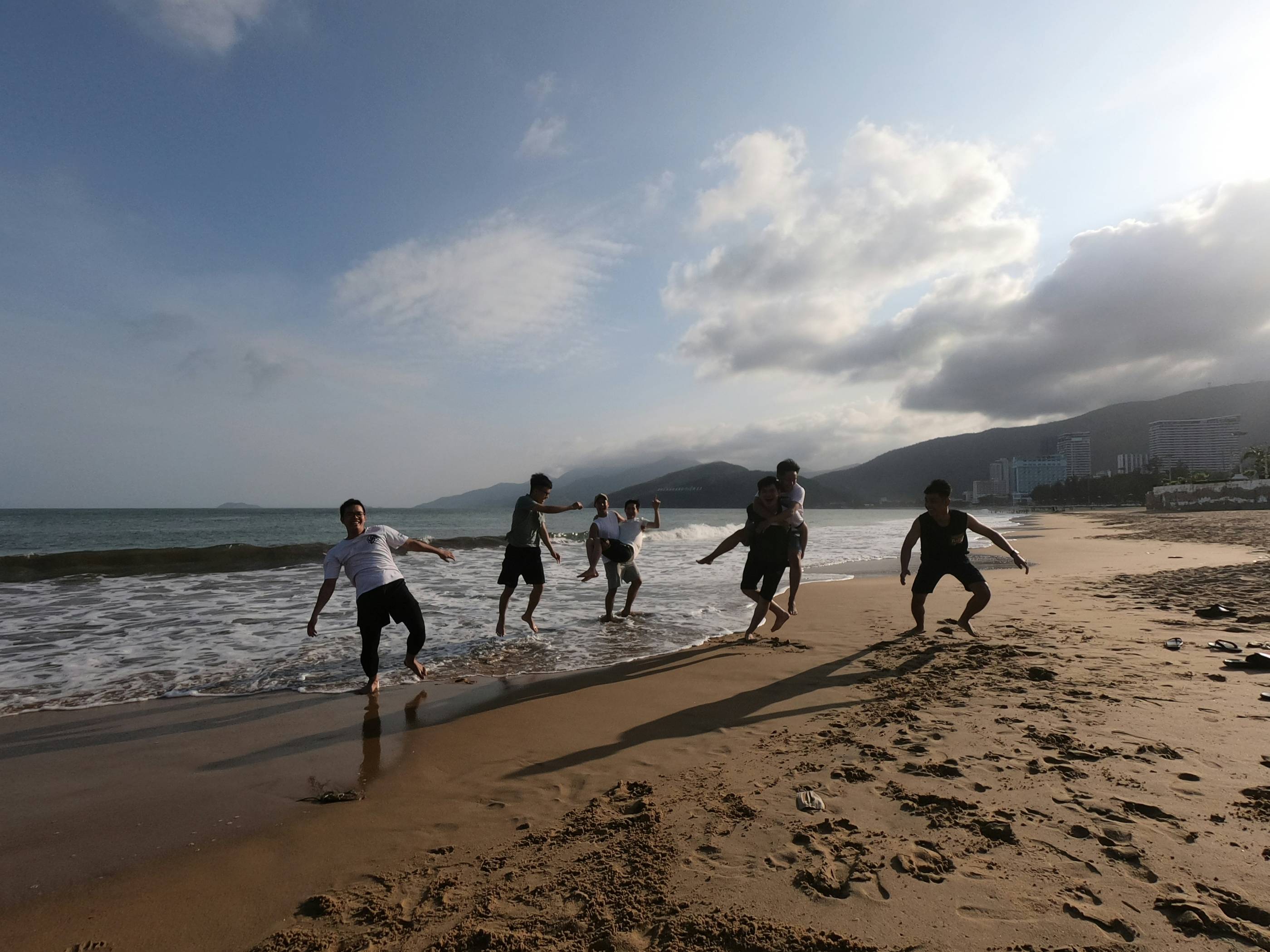 a group of people playing soccer on the beach