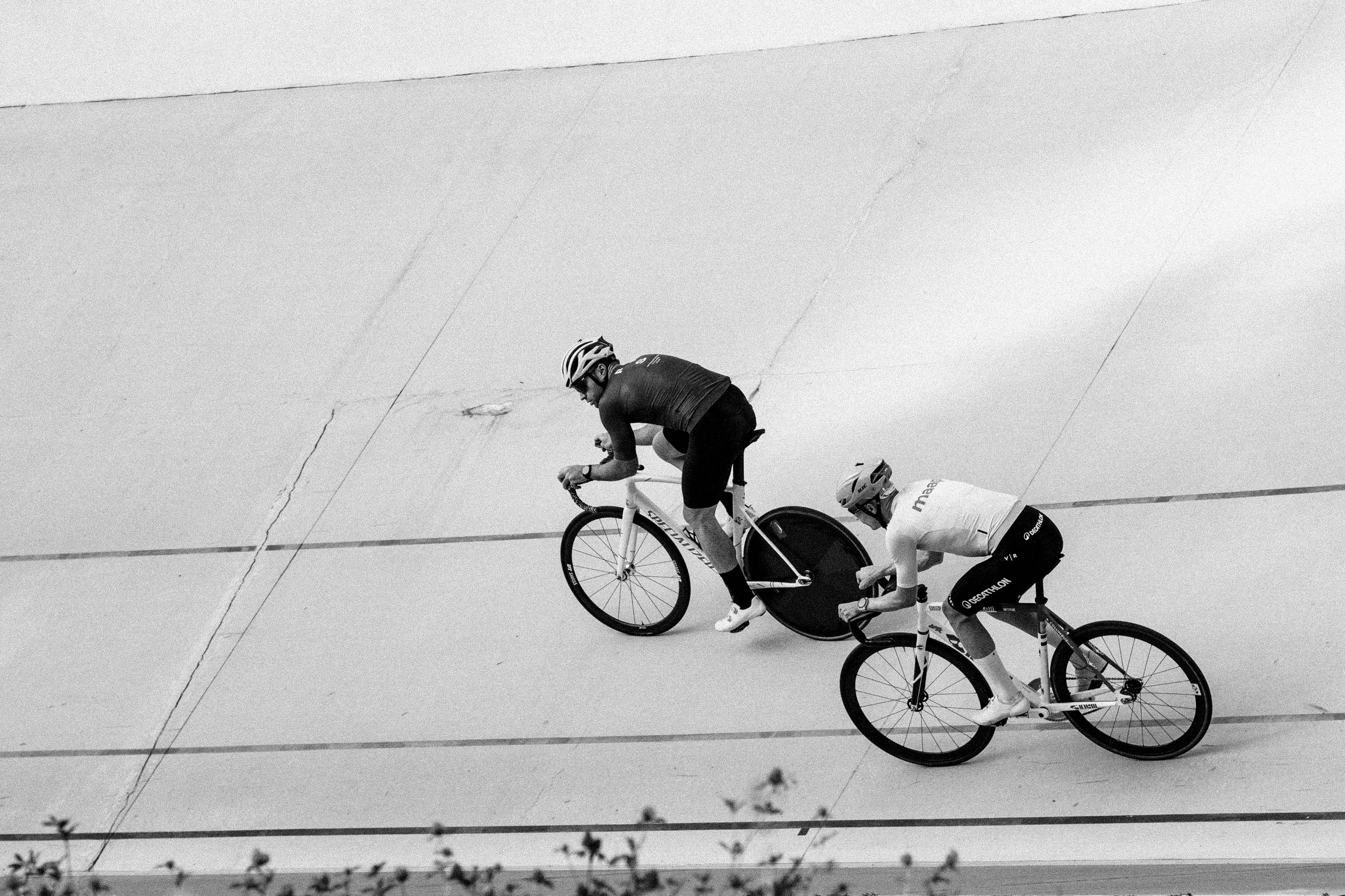 Cyclists race on a velodrome track.