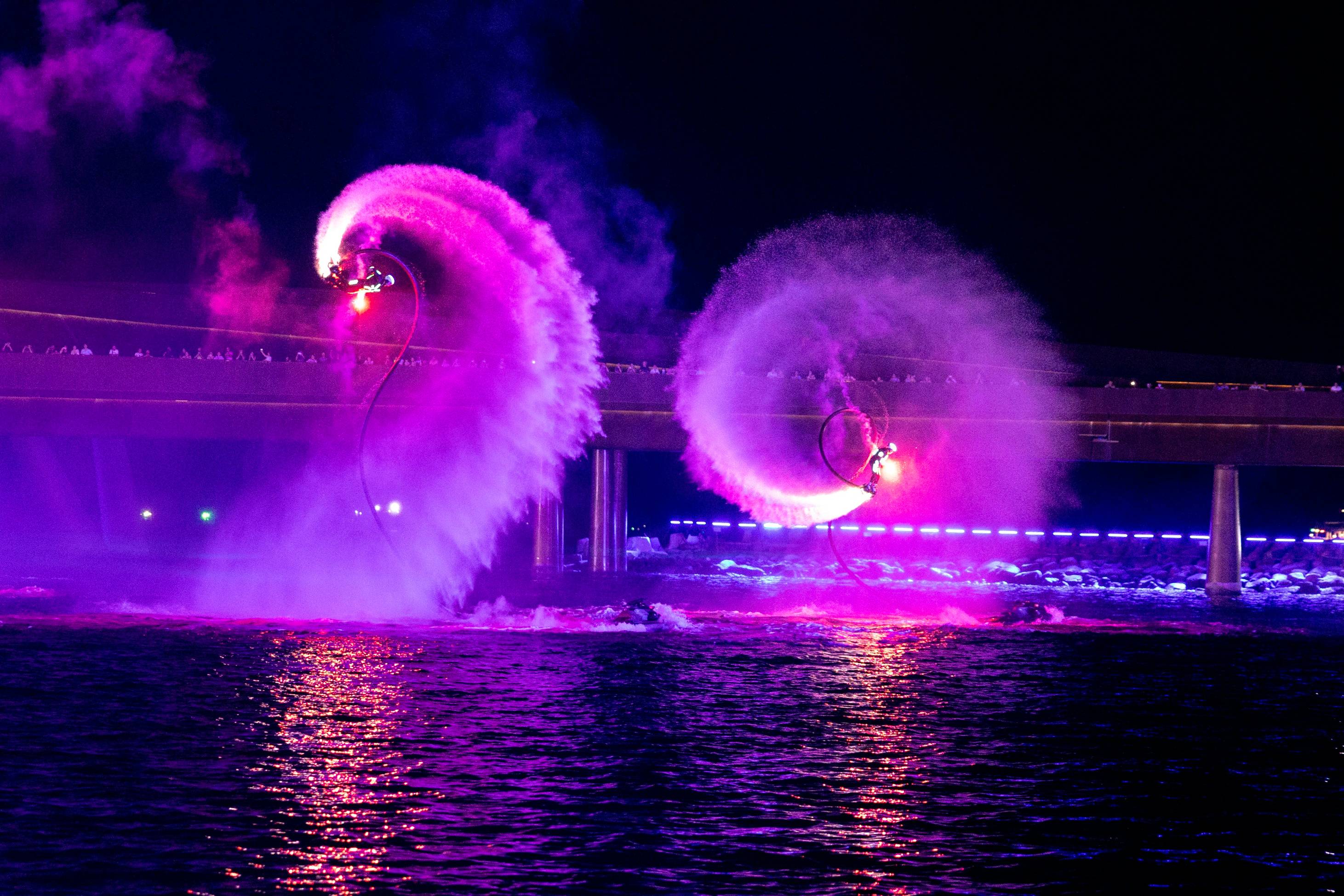 A couple of people are doing tricks in the water