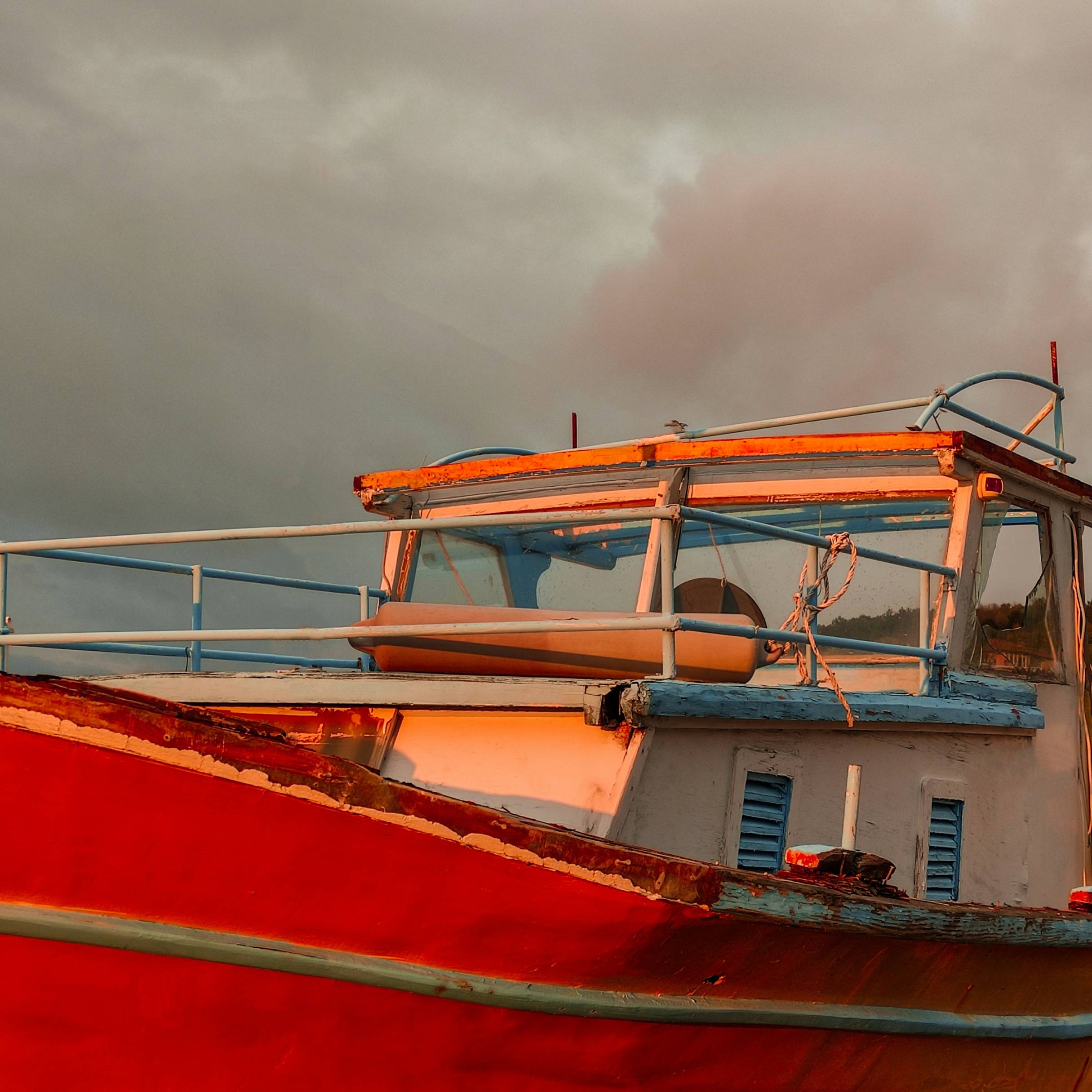 a red and white boat sitting on top of a body of water